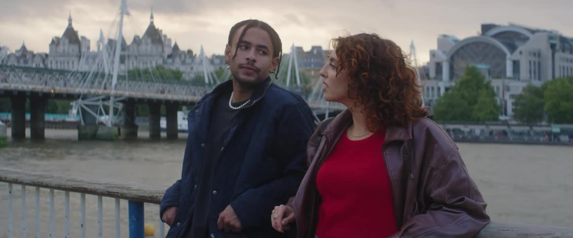 Man and woman are standing on a bridge and talking