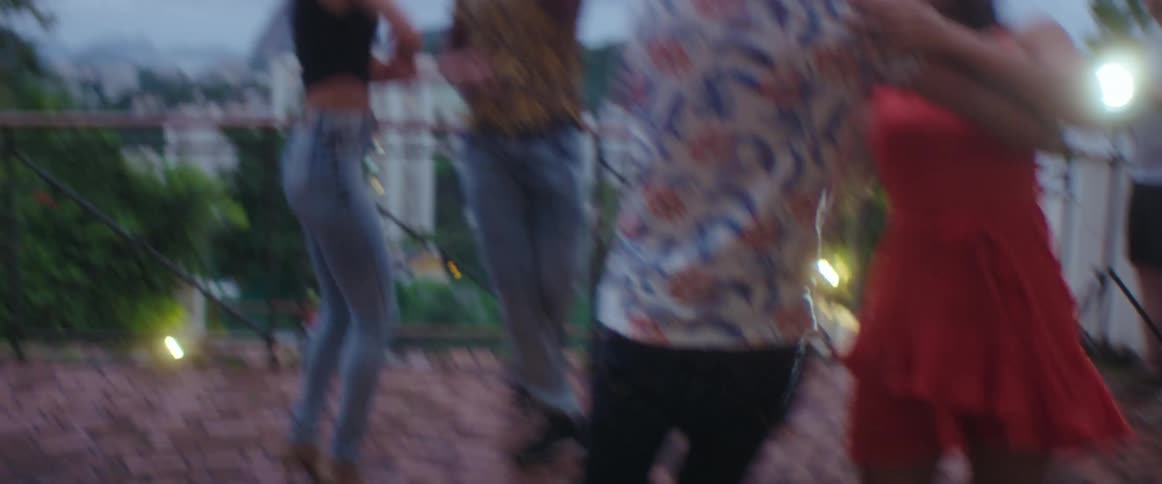 A group of people dance on an outdoor patio