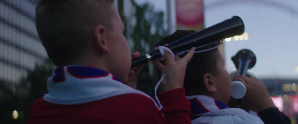 Boys play horns standing outdoors in city
