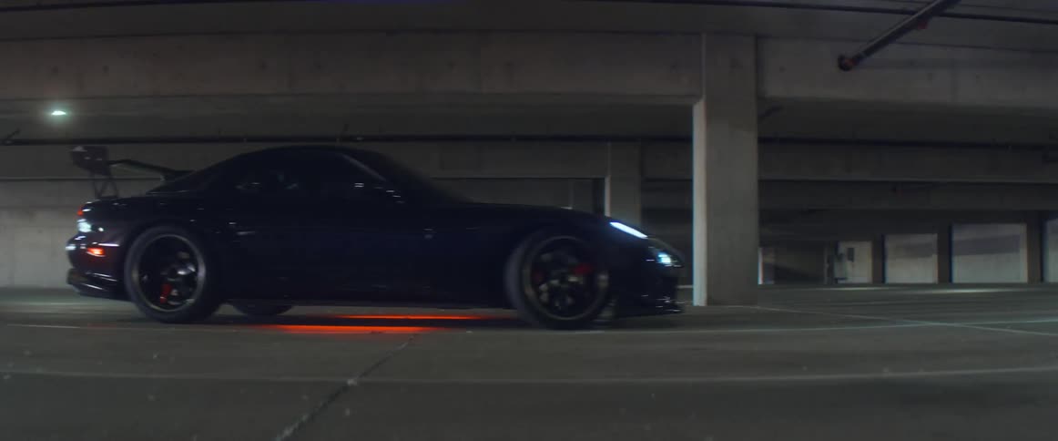 A car is driving and parks in an empty parking lot
