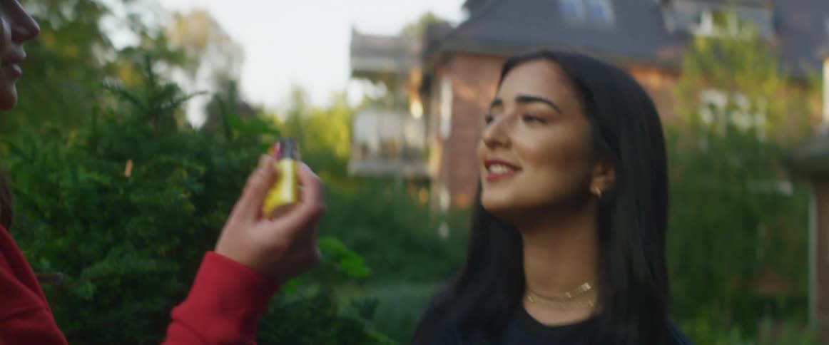 Woman gets ready to apply makeup on a friend in the backyard at morning
