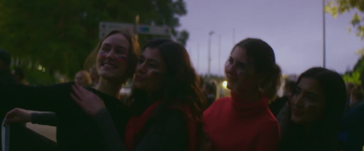 A woman holds her phone out to take a photo with her girlfriends