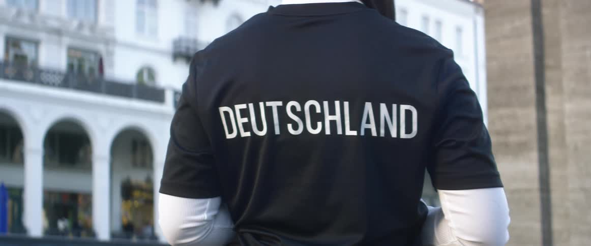 Woman standing in front of a building with a shirt with the word deutschland printed in the back
