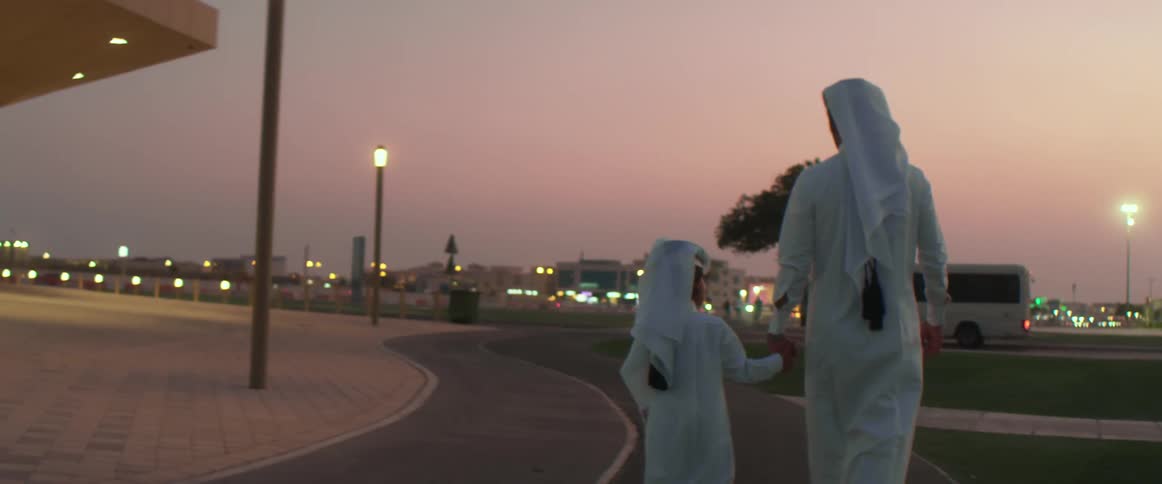 Two people in robes walk down the walkway