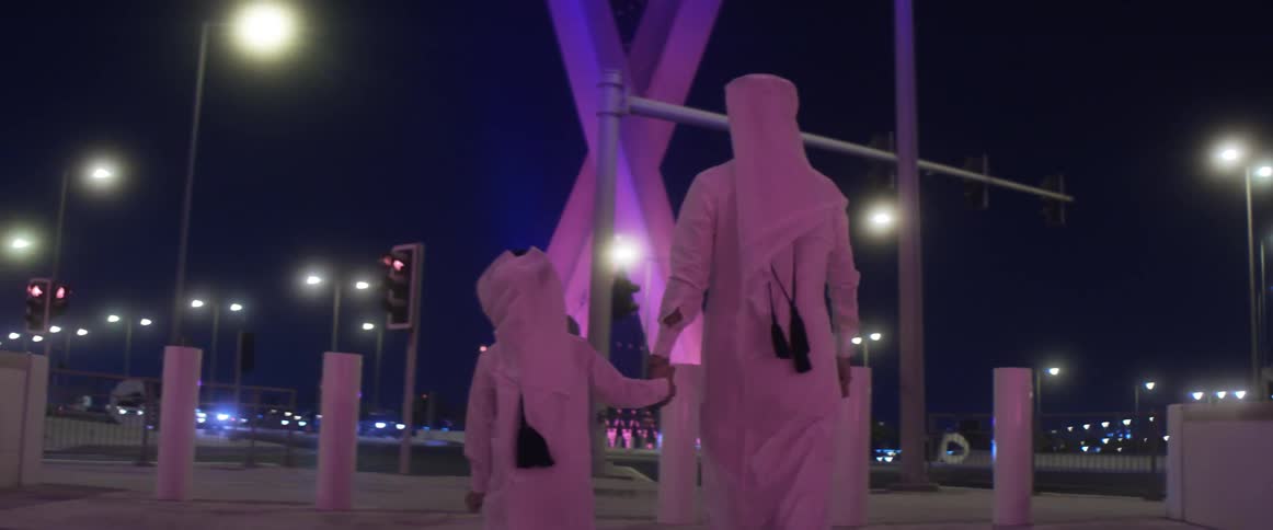Mother and child are walking through a city at night