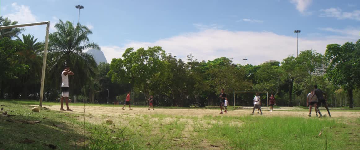 A group of kids are playing soccer outdoors in spring