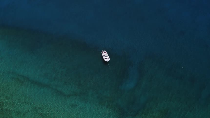 A boat slowly travels on the ocean during the day