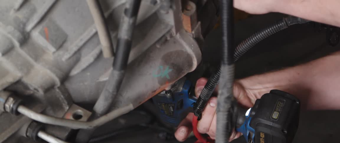 Mechanic repairs car engine using drill at the garage