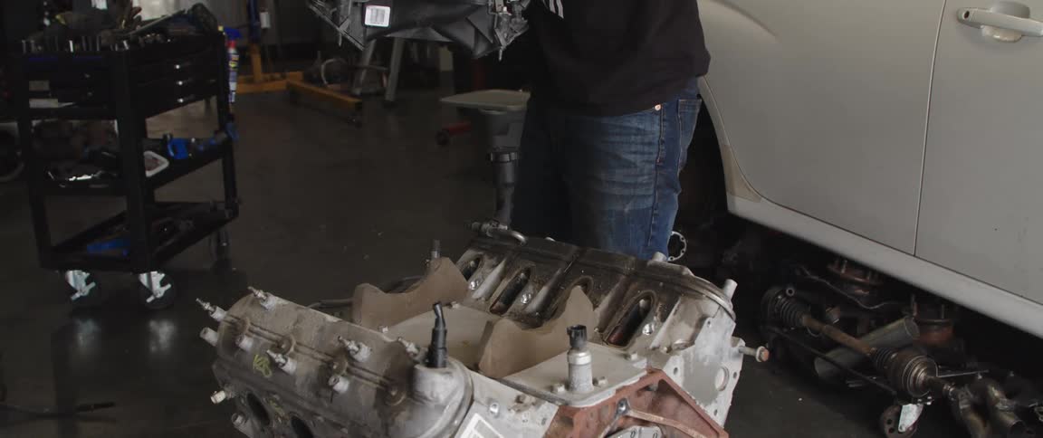 Mechanic disassembling an engine inside an auto repair shop
