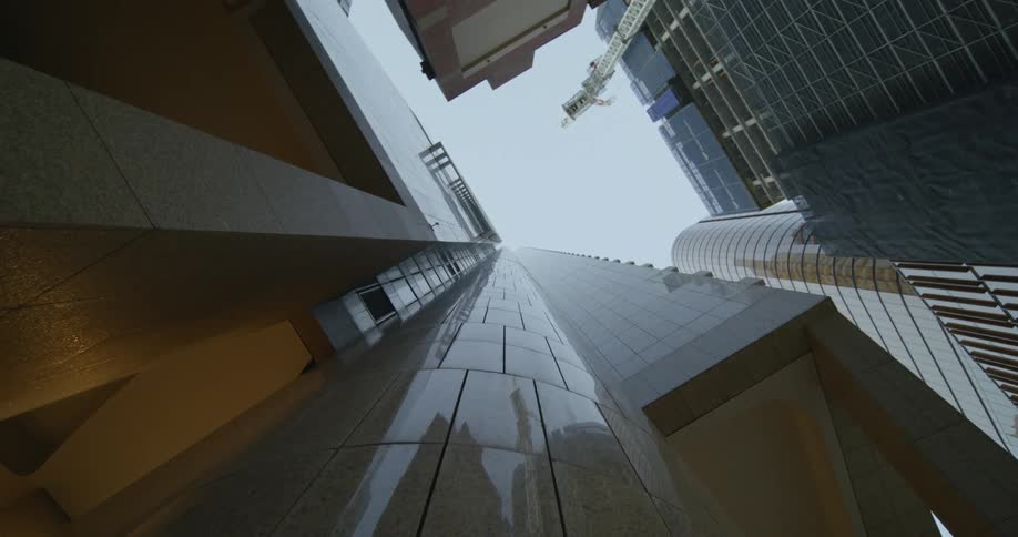 Worms eye view of a construction crane by a skyscraper