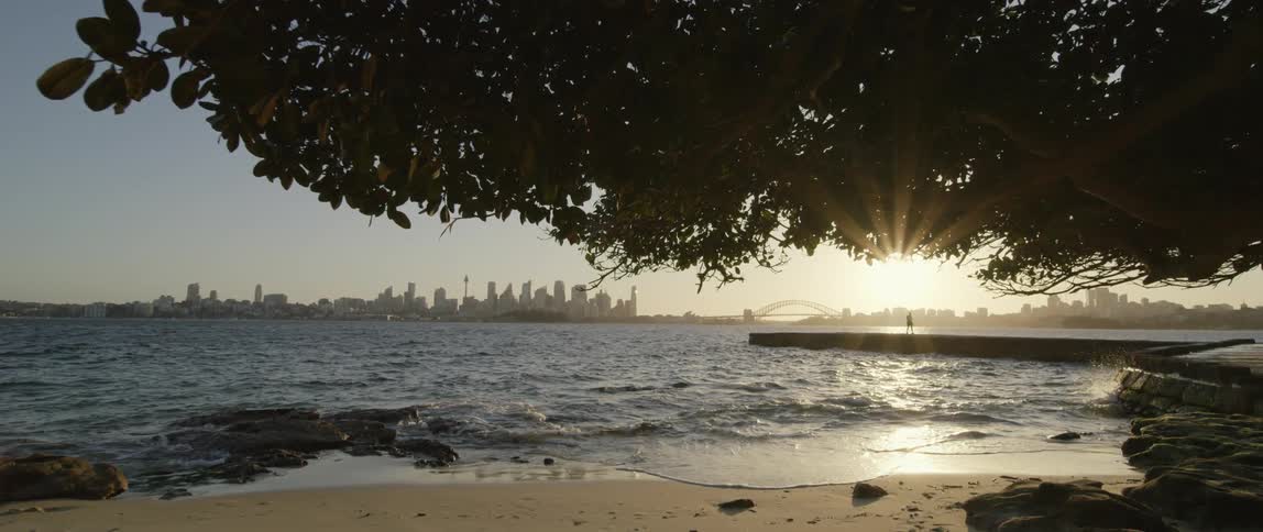 The sun is setting in the horizon of the beach