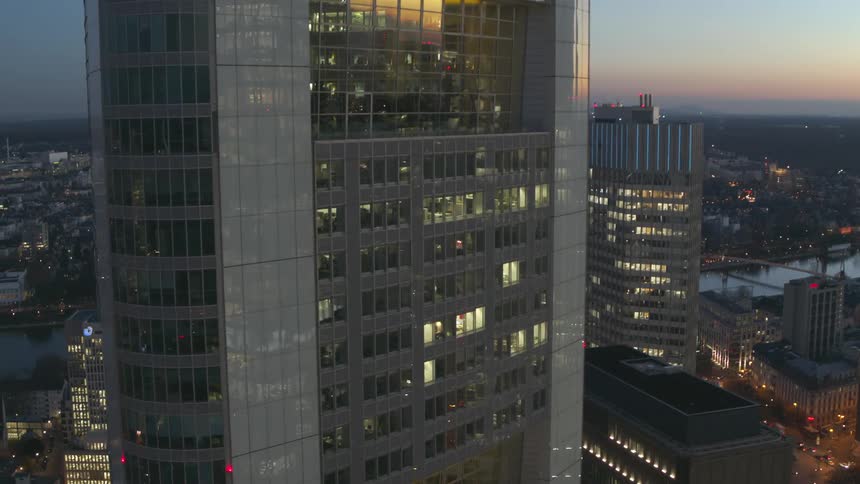 Glass on skyscrapers sitting a couple blocks from the river reflects the red tinted horion