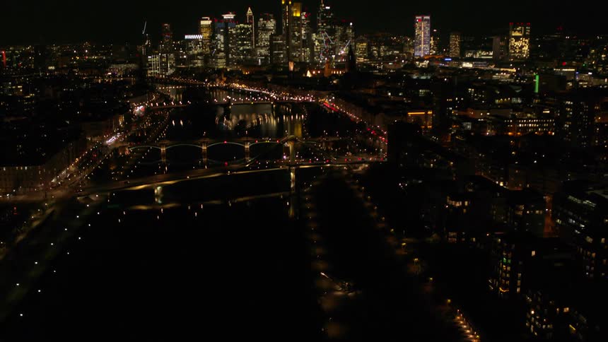 Aerial view of a city skyline at night is displayed