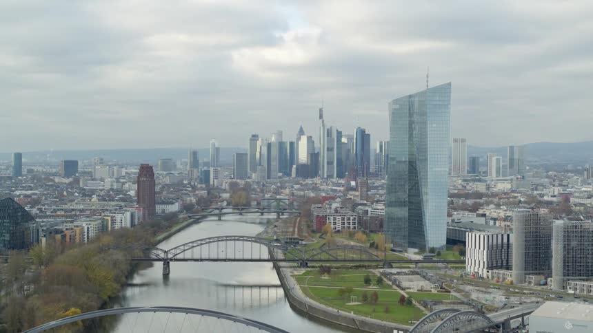 Aerial view of bridges over river and city skyline under clouds