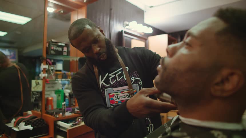 A barber shaving a mans beard