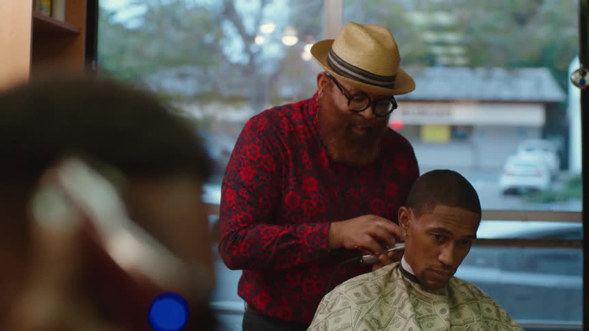 A barber cutting a mans hair