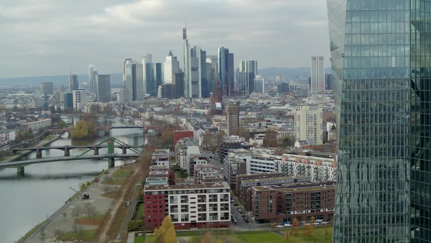 A wide river runs alongside a city with tall skyscrapers