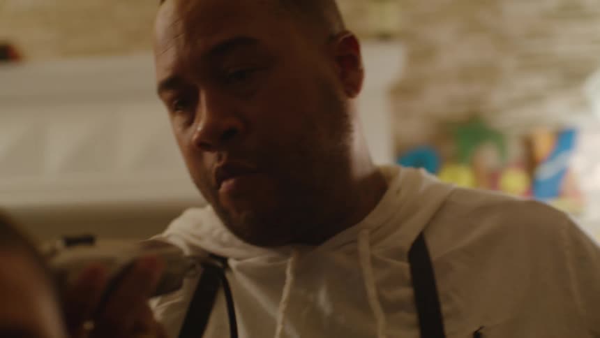 A barber closely shaves a mans head