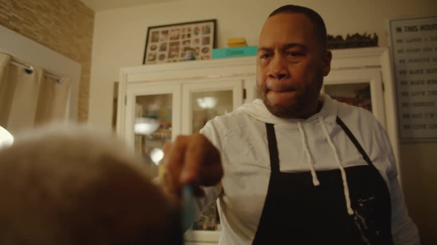 A barber combs a clients hair into place