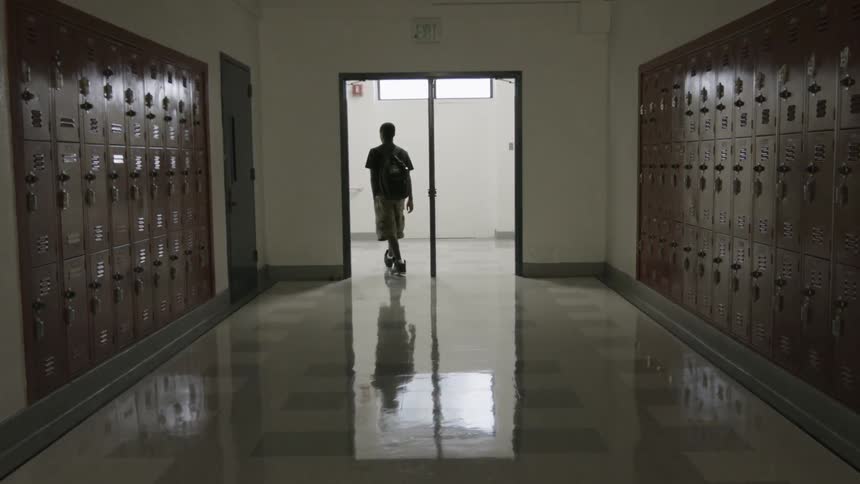A man walks through an empty hallway