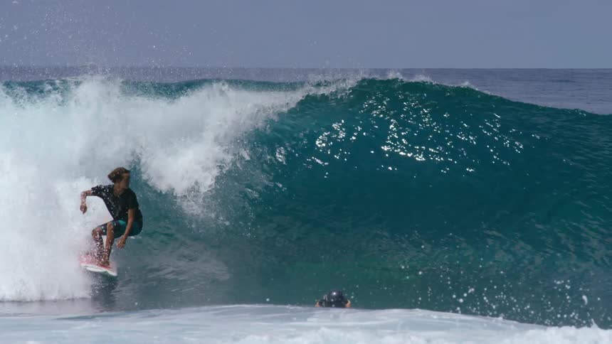 A surfer rides a wave in the ocean
