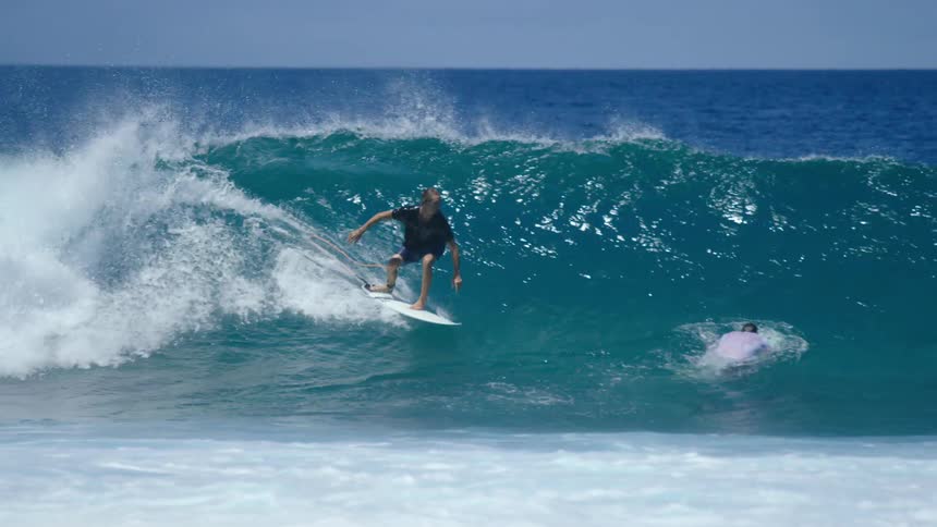 Two men are surfing on ocean waves in spring