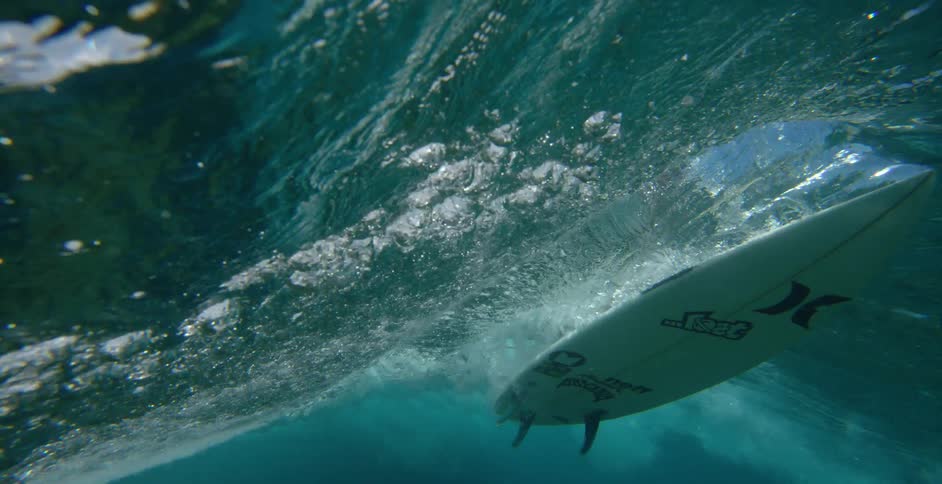 Surfer rides wave that casts shadow on seafloor