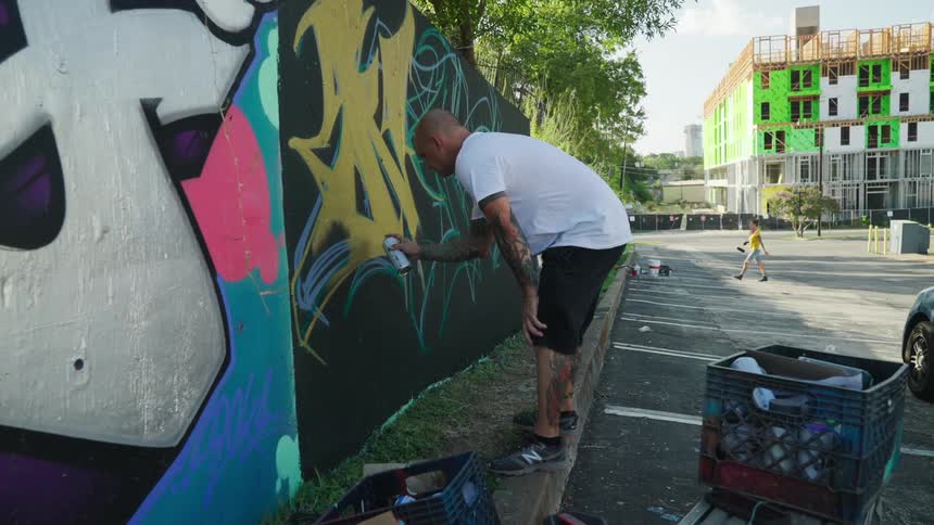 Graffiti artist working on wall