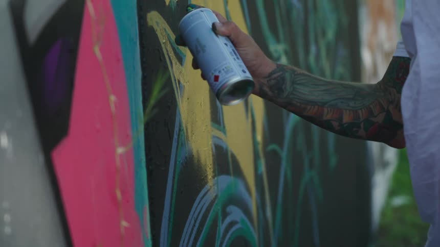 A man spray painting on a wall