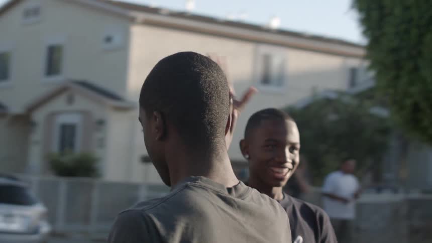 Some boys high five and turn around