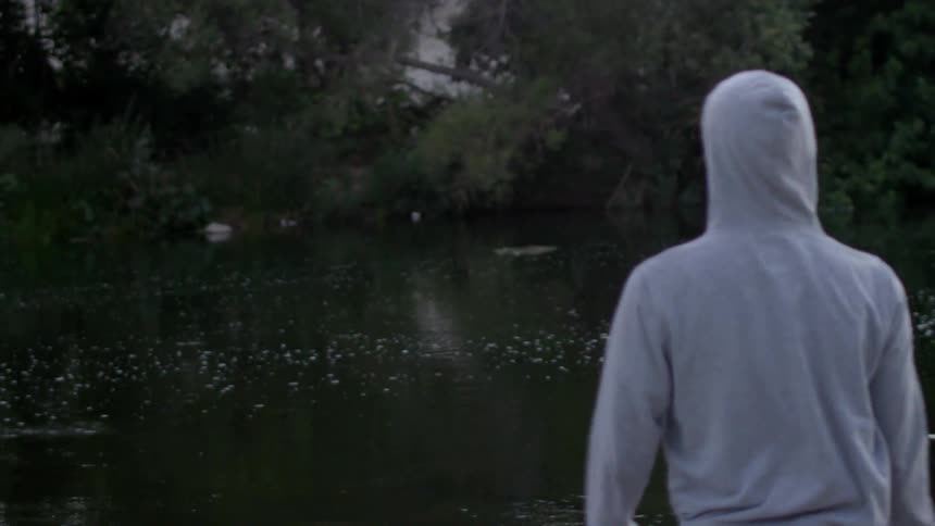 A person throws a rock in a stream