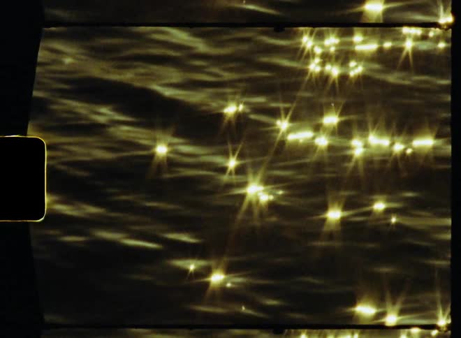 Video footage of the sun setting above a body of water is displayed