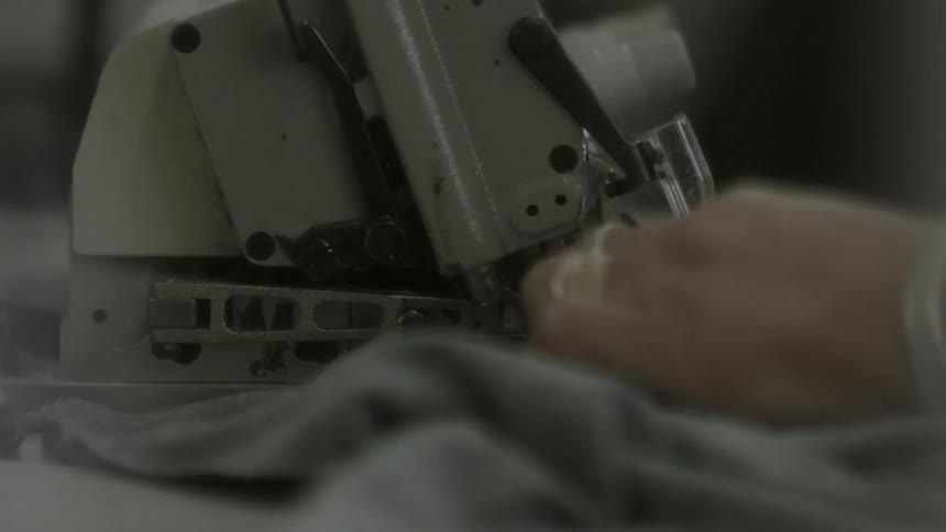 A person is using a sewing machine on fabric