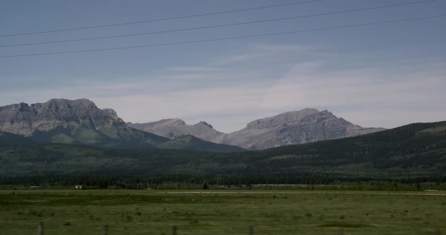 A mountain past a green field