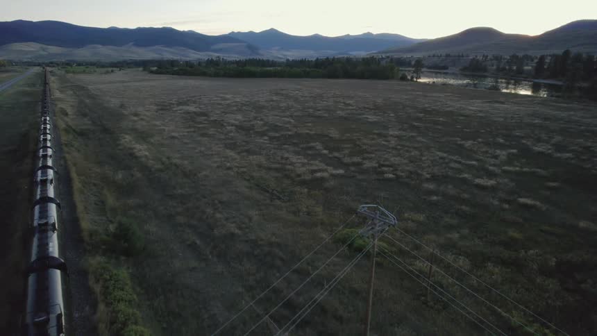 A train is moving through a rural area