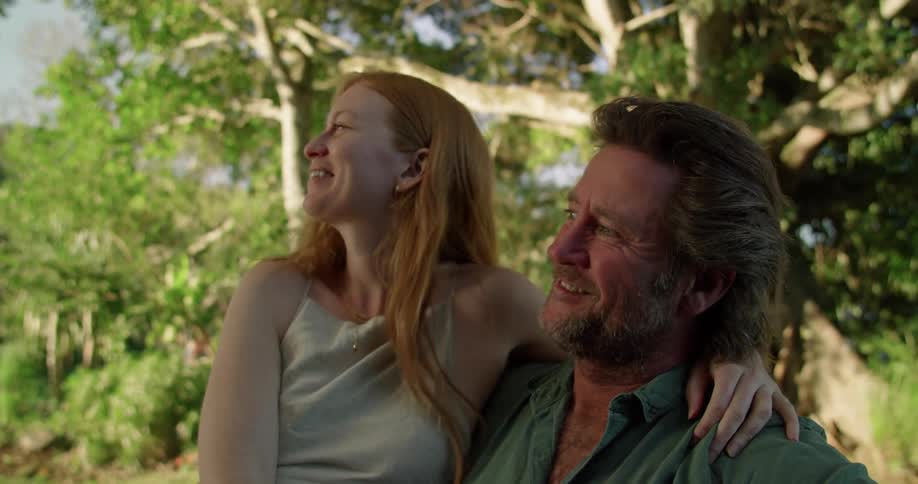 Husband and wife kiss outdoors in spring