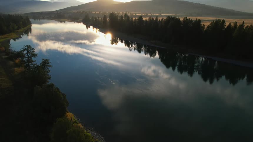 The smooth water of a river reflects the sky