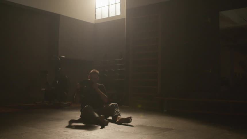 A man is exercising while sitting indoors