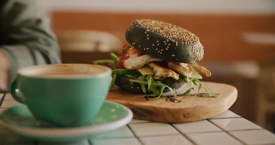 A person serves a sandwich on the counter