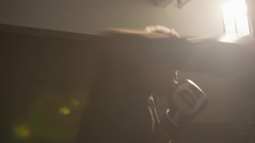 A man is exercising by using a punching bag