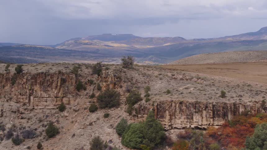 Aerial view of the cliffs on the side of a hill in the badlands near the mountains