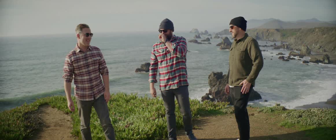 Three men are talking near the coast in spring