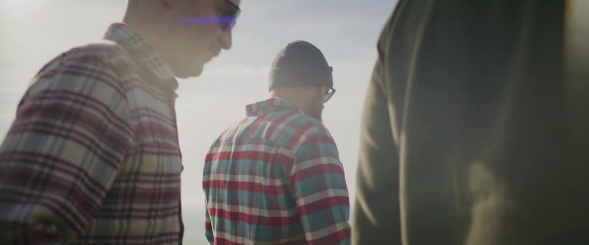 Three men are hiking outdoors at sunset