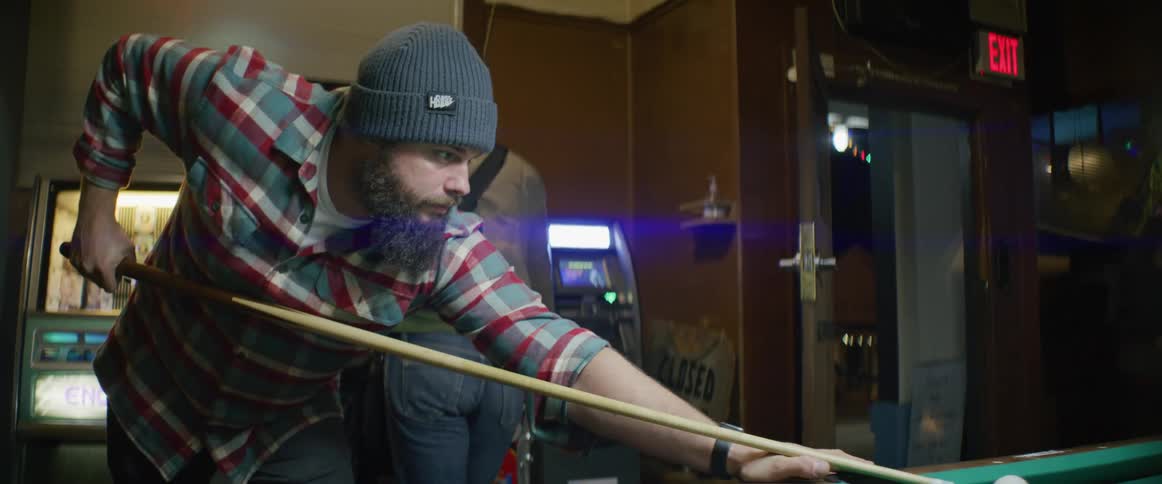 A man is playing pool in the pool hall