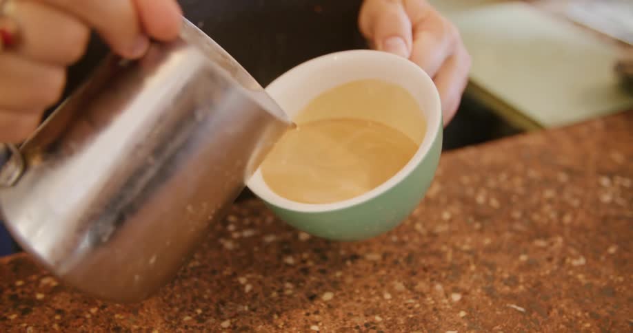 Brarista creates coffee art in white coffee cup