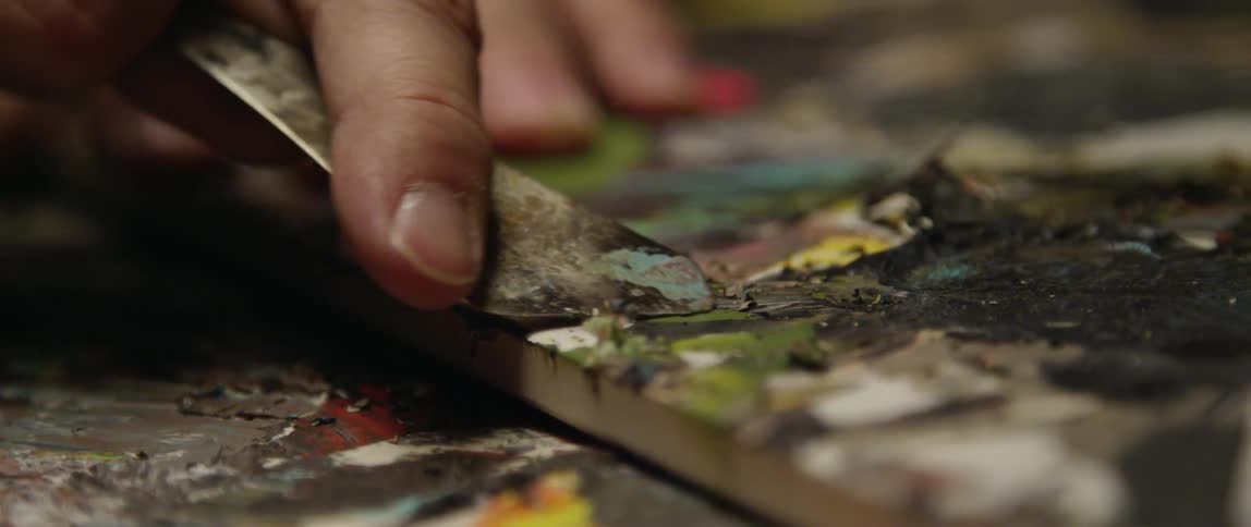 Paint is being scraped from a board