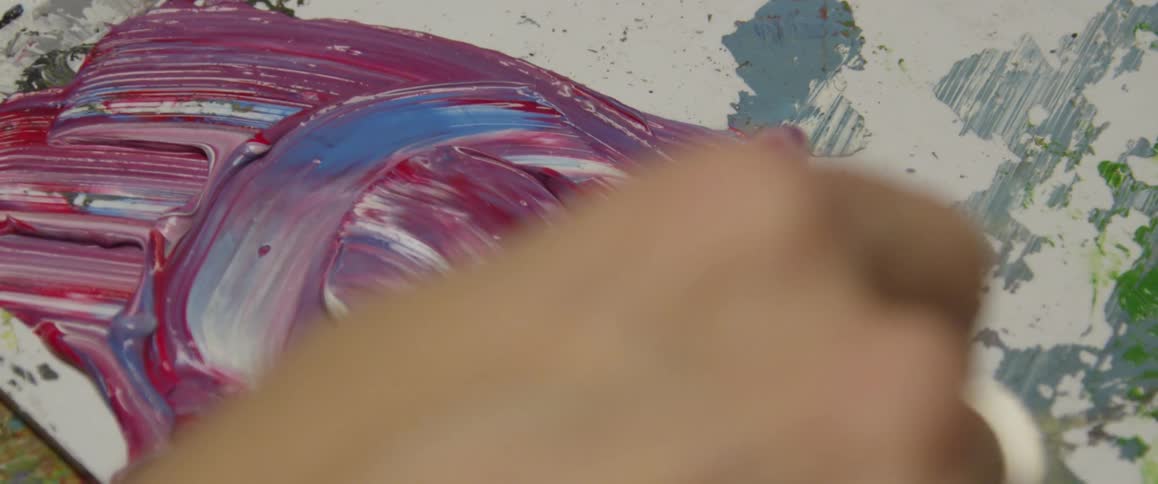 A brush is mixing paint