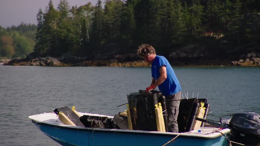 A man is preparing nets on a small boat