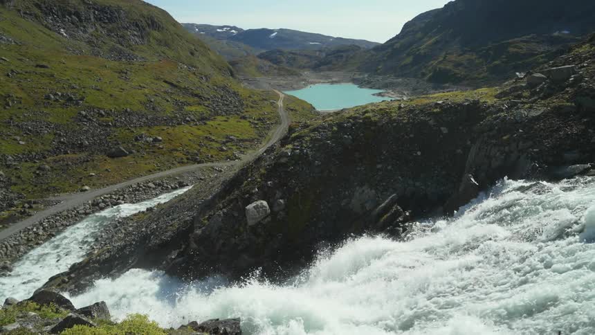 A waterfall is flowing in a mountainous area