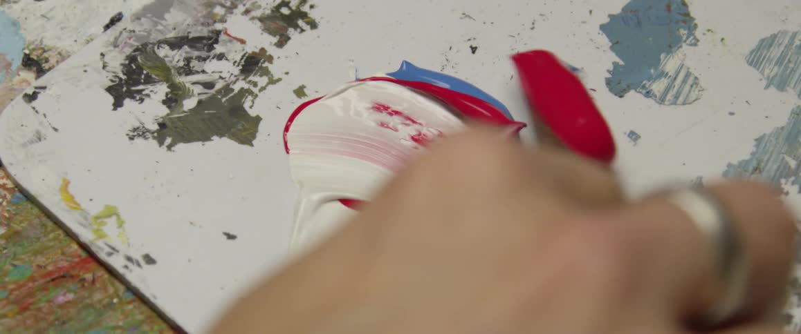 Paint is being mixed on a board